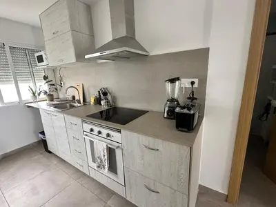 a kitchen with a sink and a stove top oven at Abadesa Apartments in Benetúser