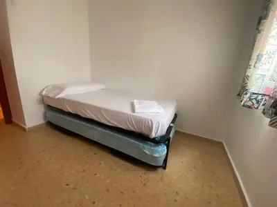 a small bed in a corner of a room at Perla III Solo Familias Serviplaya in Casas Las Basas