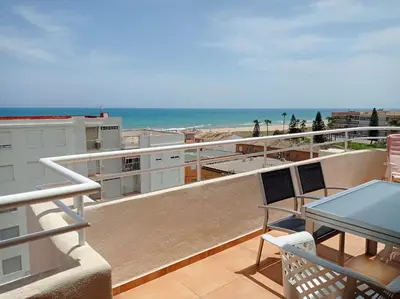 a balcony with a table and a view of the beach at Perla III Solo Familias Serviplaya in Casas Las Basas
