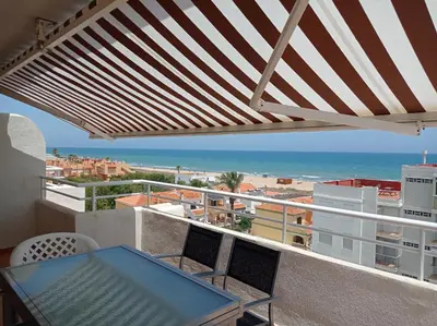 a balcony with a table and a view of the beach at Perla III Solo Familias Serviplaya in Casas Las Basas