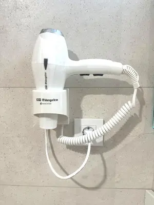 a white hair dryer is attached to a wall at Marina Azura in Valencia