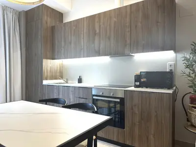 a kitchen with wooden cabinets and a table with chairs at Marina Azura in Valencia