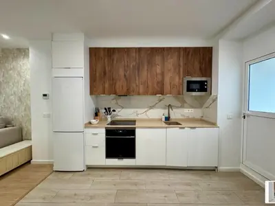 a kitchen with white cabinets and a black appliance at Reino Vlc - centrico y amplio piso in Valencia