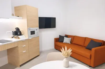 a living room with a couch and a kitchen at Olmaya Flats Valencia in Valencia