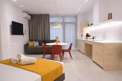 a room with two beds and a table and a kitchen at Olmaya Flats Valencia in Valencia