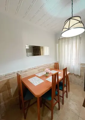 a dining room with a wooden table and chairs at Casa Burriana con sauna in Burriana