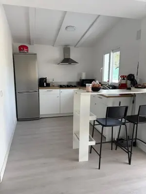 a kitchen with white cabinets and a table and chairs at Chalet con piscina dogfriendly in Algar de Palancia