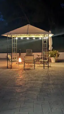 a group of chairs under an umbrella at night at Chalet con piscina dogfriendly in Algar de Palancia