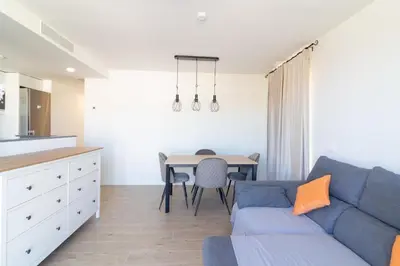 a living room with a blue couch and a table at Global Vacacional, Apartamento con piscina en Puerto de Sagunto in Puerto de Sagunto