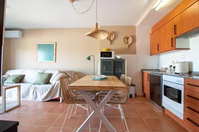 a kitchen and living room with a table and a couch at Global Vacacional, Planta baja con piscina en Almenara in Almenara