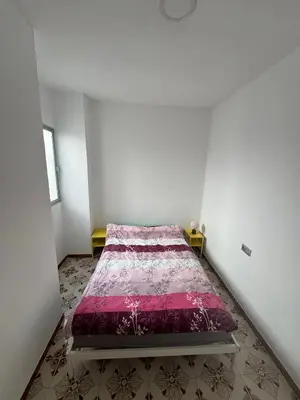 a bedroom with a bed with a pink comforter at Ático en el centro con terraza in Valencia