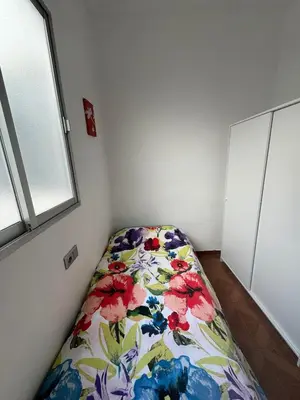 a bedroom with a bed with a floral blanket at Ático en el centro con terraza in Valencia