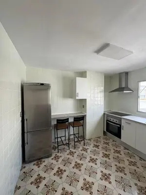 a kitchen with a refrigerator and some chairs in it at Ático en el centro con terraza in Valencia