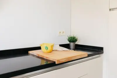 a kitchen counter with a wooden cutting board on it at Premium, Lux & Comfort by the Sea in Valencia