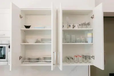 a white cabinet with plates and dishes in it at New! Comfort and Style Steps from Everything in Valencia
