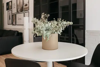 a white table with a vase of flowers on it at New! Comfort and Style Steps from Everything in Valencia