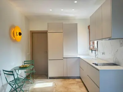 a kitchen with white cabinets and a small table with a yellow face on it at Piscina & Espacio & Confort entre Playa y Montaña in San Antonio de Banageber