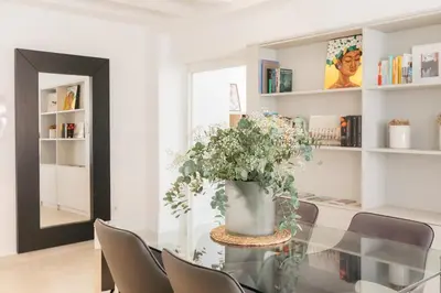 a dining room with a glass table with a vase of flowers at Comfort & Charm in the Center in Valencia