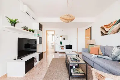 a living room with a couch and a tv at Urban Oasis near the beach in Puerto de Sagunto