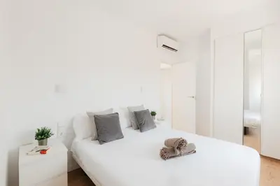 a white bedroom with a large white bed with a white couch at Penthouse with Terrace 2 Bedrooms 2 Bathrooms in Valencia