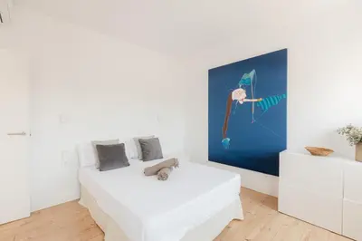 a bedroom with a white bed and a painting on the wall at Penthouse with Terrace 2 Bedrooms 2 Bathrooms in Valencia