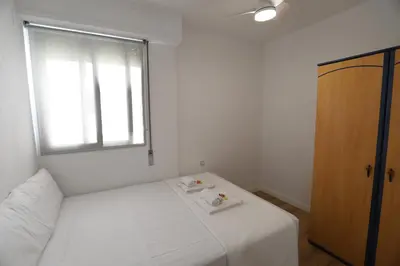 a small bedroom with a bed and a window at Panoramic Mediterranean Views Beachfront in Puerto de Sagunto