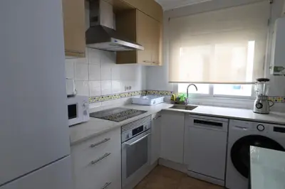 a white kitchen with white appliances and a window at Panoramic Mediterranean Views Beachfront in Puerto de Sagunto