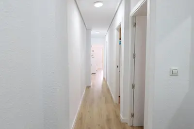 an empty hallway with white walls and wood floors at Panoramic Mediterranean Views Beachfront in Puerto de Sagunto