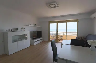 a living room with a dining table and a television at Panoramic Mediterranean Views Beachfront in Puerto de Sagunto