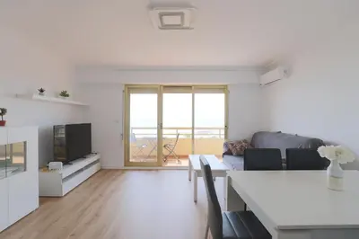 a white living room with a table and a couch at Panoramic Mediterranean Views Beachfront in Puerto de Sagunto