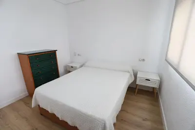 a small bedroom with a bed and a dresser at Panoramic Mediterranean Views Beachfront in Puerto de Sagunto