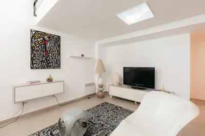 a white bedroom with a bed and a tv at Grand Villa with Pool in Sagunto