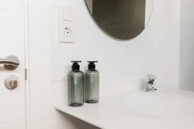 two bottles on a bathroom counter with a mirror at Grand Villa with Pool in Sagunto