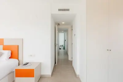 a bedroom with a bed and a table and a hallway at Grand Villa with Pool in Sagunto