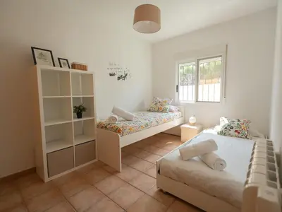 a small bedroom with two beds and a window at Villa a un paso de Valencia in Riba-Roja De Turia
