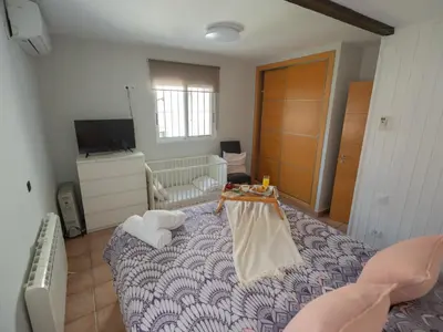 a bedroom with a bed with a crib and a tv at Villa a un paso de Valencia in Riba-Roja De Turia