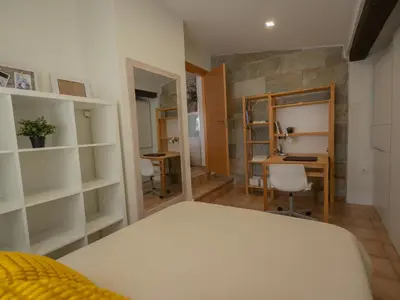 a bedroom with a bed and a desk in a room at Villa a un paso de Valencia in Riba-Roja De Turia