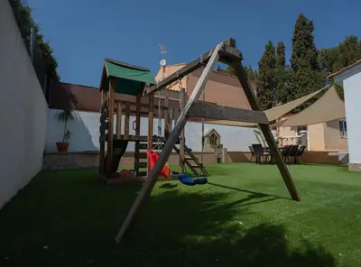 a swing set in a yard with green grass at Villa a un paso de Valencia in Riba-Roja De Turia