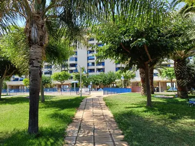 a path in a park with palm trees and a building at Valencia Playa Patacona Resort in Valencia