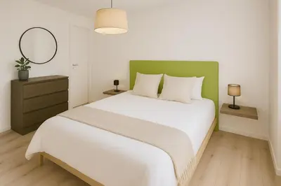 a bedroom with a large white bed with a green headboard at Serrano flat in Valencia