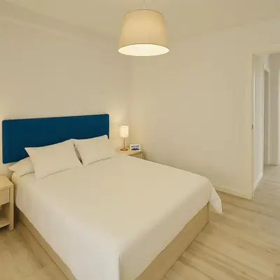 a bedroom with a large white bed with a blue headboard at Serrano flat in Valencia