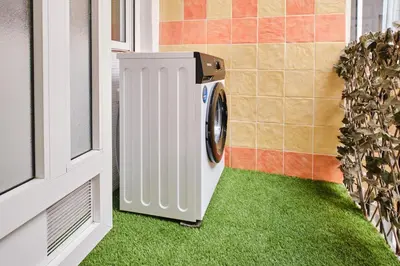 a washing machine in a room with green grass at Serrano flat in Valencia