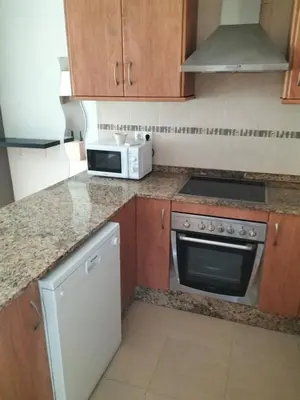 a kitchen with a counter and a table with chairs at Apartamento en playa de Moncofar con wifi y aire acondicionado in Moncófar