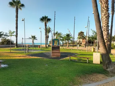 a park with palm trees and a playground at Apartamento en playa de Moncofar con wifi y aire acondicionado in Moncófar