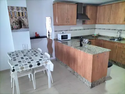 a kitchen with wooden cabinets and a sink at Apartamento en playa de Moncofar con wifi y aire acondicionado in Moncófar