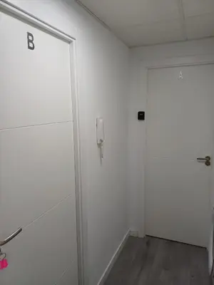 a white room with a door and a phone on the wall at loft cerca del centro de Valencia in Valencia