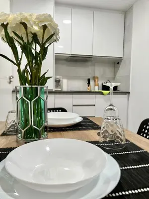 a table with a white plate and a vase with flowers at loft cerca del centro de Valencia in Valencia