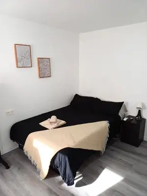 a bedroom with a black bed with a hat on it at loft cerca del centro de Valencia in Valencia