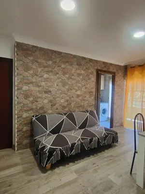 a couch in a room with a brick wall at Avenida Mediterráneo in Puerto de Sagunto