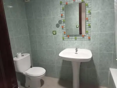 a bathroom with a toilet and a sink and a mirror at Avenida Mediterráneo in Puerto de Sagunto